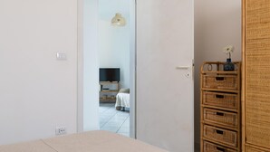 A bedroom with a bed, a wardrobe, and a television in the background. - White Sea by Wonderful Italy - Villetta Aurora (Carovigno)