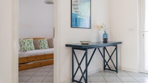 A room with a bed, a table with a bowl, and a framed picture of a sailboat. - White Sea by Wonderful Italy - Villetta Aurora (Carovigno)