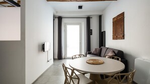 A modern dining area with a round table, wooden chairs, and a sofa. - San Michele Apartments - Lapis by Wonderful Italy (Bologna)