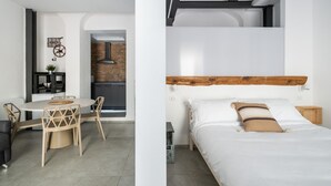 A modern, minimalist bedroom with a wooden headboard, a single bed, and a nightstand. - San Michele Apartments - Lapis by Wonderful Italy (Bologna)