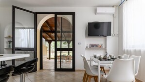 Una cocina moderna con comedor, que incluye un televisor, una cafetera y un letrero que dice "abiertos".
