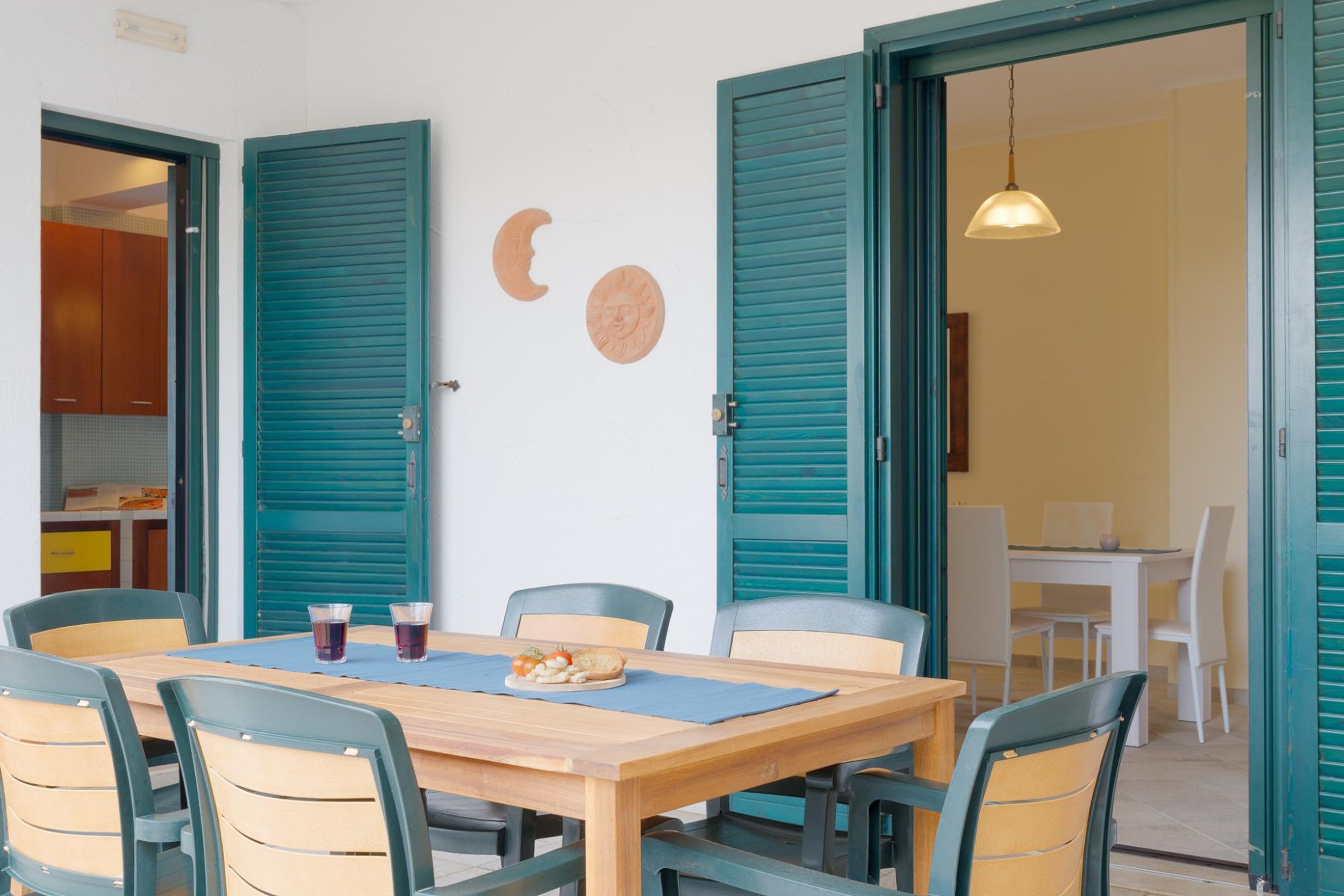 A dining area with a wooden table, six chairs, and a blue placemat.