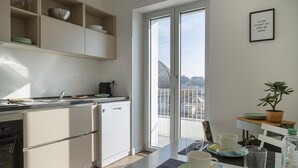 Una cocina moderna con lavavajillas, un fregadero y una ventana con vistas a un paisaje urbano.