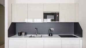 A modern kitchen with a built-in microwave, a coffee maker, and a sink. - Studio Green al Parco by Wonderful Italy (Bologna)