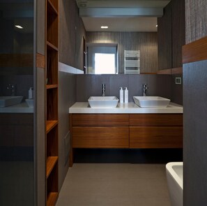 A modern bathroom with two sinks, wooden cabinets, and a mirror. - Elegant Apartment at Chiaia by Wonderful Italy (Naples)