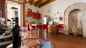 Una sala de estar moderna con comedor, cocina y un arco de piedra.