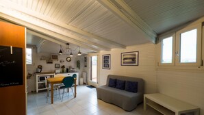 A cozy, well-lit room with a dining area, a sofa, and a bench.
