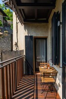 Una terraza de madera con una mesa y sillas, una botella de vino y una copa sobre la mesa.
