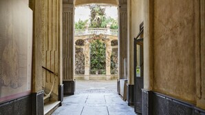 Un couloir donnant sur une arche richement décorée qui mène à un balcon.