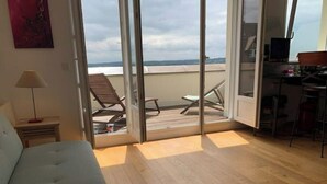 Una stanza con un letto, una scrivania, una sedia e un balcone con vista.