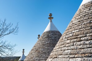 Ein Steinhaus mit mehreren kegelförmigen Dächern, verziert mit kugelförmigen Ornamenten.