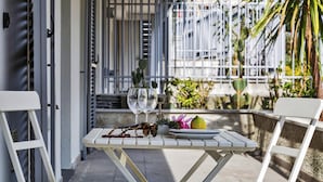 A white table with a plate, a lemon, and a decorative item on a balcony. - Viviboccadasse by Wonderful Italy - Tulipano (Genoa)