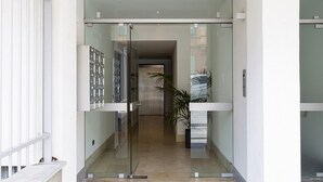 A modern hotel entrance with a glass door, a visible elevator, and a potted plant. - Viviboccadasse by Wonderful Italy - Tulipano (Genoa)