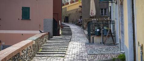 A cobblestone street leading to a building with a sign reading "Amedeo Antica Gelateria".