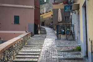 Une rue pavée menant à un bâtiment sur lequel on peut lire l’inscription « Amedeo Antica Gelateria ».