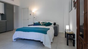 Un dormitorio con cama, mesita de noche, lámpara y armario.