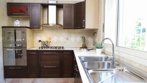 Une cuisine moderne avec des meubles de couleur brun foncé, un four en acier inoxydable, une cuisinière à gaz et un évier.