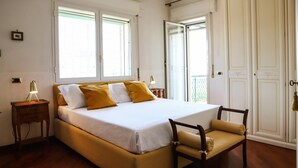 Une chambre à coucher avec un lit, une table de chevet, une chaise et une armoire.