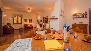 A dining area with a wooden table set for breakfast, including croissants and a newspaper. - Daller Bianca - BK in Soiano del Lago (Soiano del Lago)
