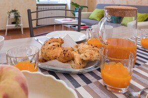 A breakfast setting with croissants, orange juice, and a pitcher. - Cavour 20 - Casa Cavour a Pochi Passi da Piazza Sa (Turin)