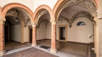 An interior courtyard with brick flooring, arched ceilings, and a central open space.