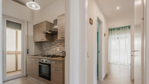 Una cocina moderna con armarios de madera, una estufa a gas y un horno empotrado.