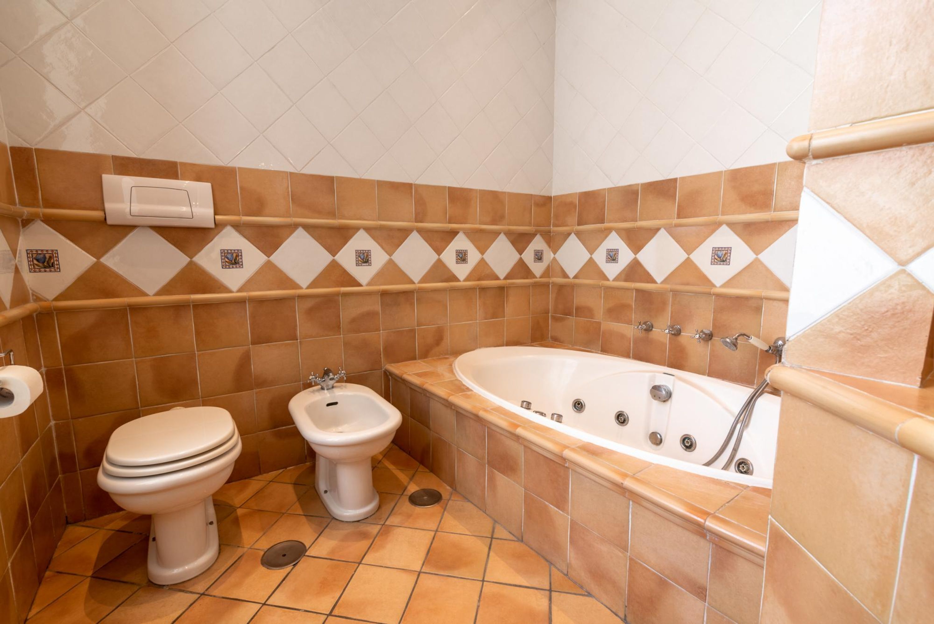 Un baño con inodoro, bidé y bañera.