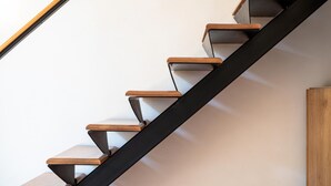 A modern staircase with wooden steps and a black metal railing. - Maiorani Family Apartment nel Centro di Napoli (Naples)