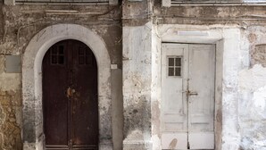 An old building with two doors, one arched and one rectangular, both appear aged and worn. - Maiorani Family Apartment nel Centro di Napoli (Naples)