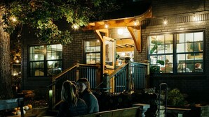 A building with a brick facade, large windows, and a staircase leading to an upper level. - Sleeps 20! Fire Pit, Hot Tub & Amazing Location! (Asheville)