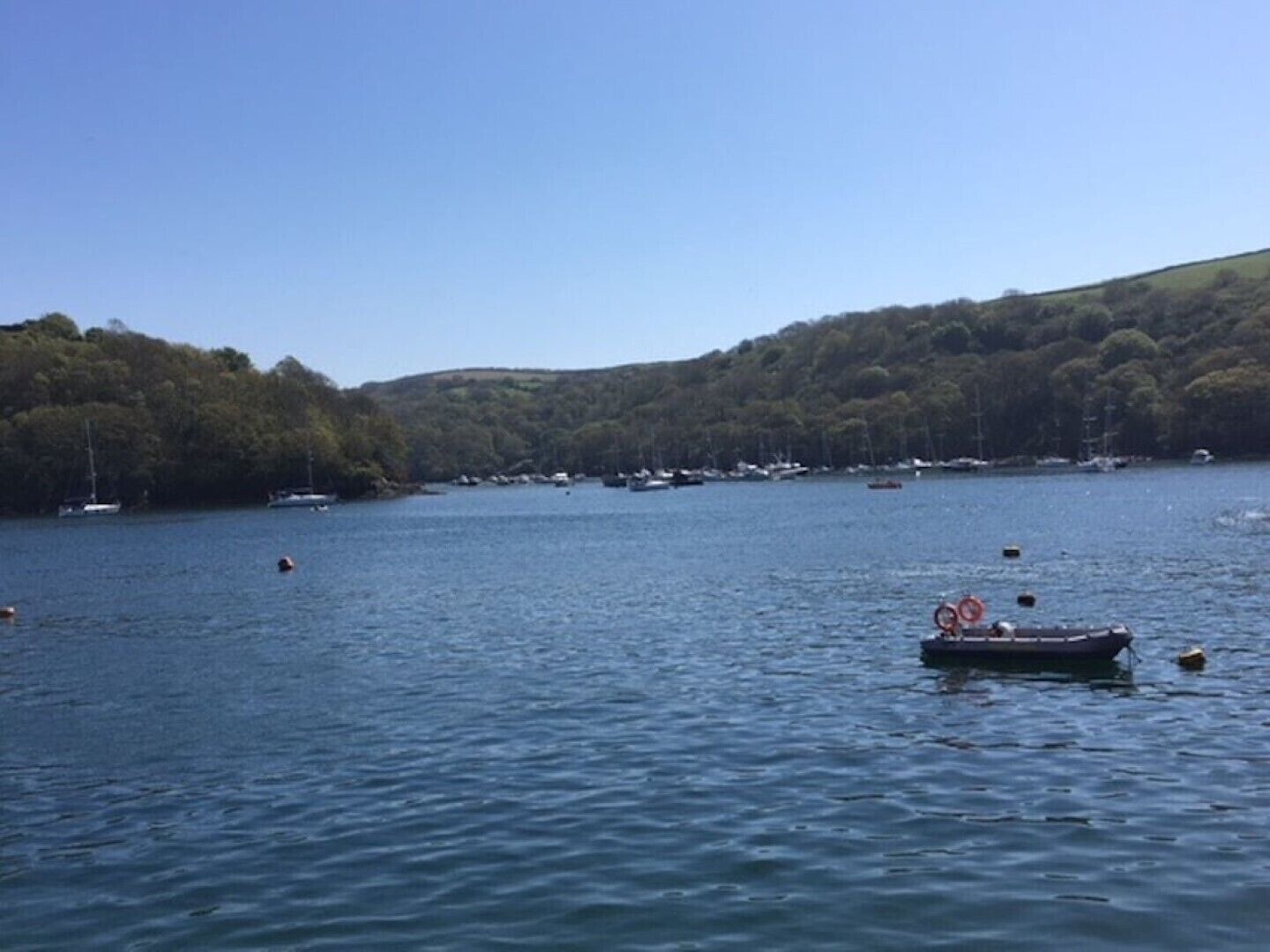 A calm lake with boats and a small dock.
