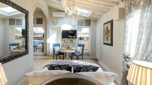 Una habitación acogedora con chimenea, un comedor con mesa y sillas, y un espejo grande en la pared.