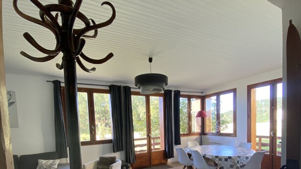A spacious living room with a dining area, large windows, and a ceiling with a unique design. - Cosy family apartment in the heart of the Pyrenees (Font-Romeu-Odeillo-Via)