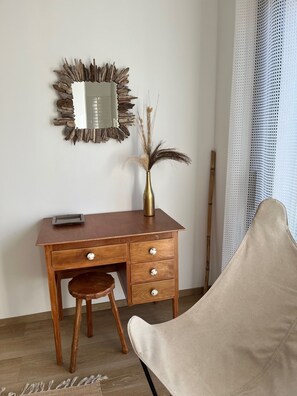 A wooden desk with drawers and a vase with dried plants, a chair, and a mirror with a natural frame. - Contemporary villa for 2 people, private pool, enclosed grounds  (San-Gavino-Di-Carbini)