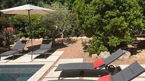 A poolside area with lounge chairs, a pool, and a pergola with an umbrella. - Contemporary villa for 2 people, private pool, enclosed grounds  (San-Gavino-Di-Carbini)