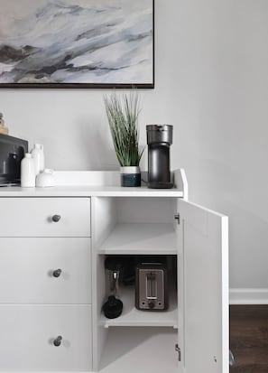 A white cabinet with drawers, a coffee maker, a toaster, and a plant on top. - Nov Dates Open-Pet friendly near Chatt hospital (Chattanooga)