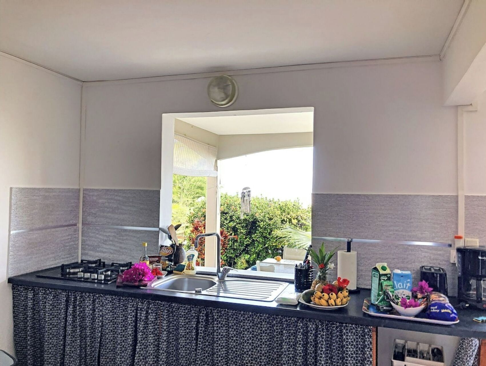 A modern kitchen with a large island, a sink, and various kitchen items.