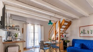 A compact living space with a kitchen, dining area, and a blue sofa. - Sant Onofrio Mini Loft by Wonderful Italy (Palermo)