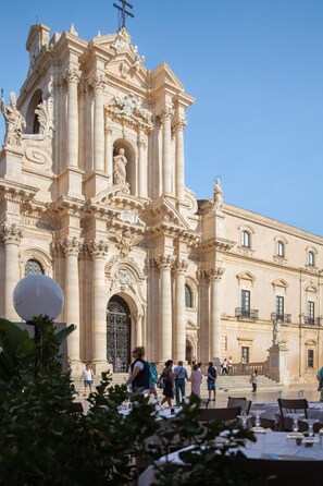 A historic building with classical architecture, featuring columns, statues, and ornate details. - Casa Darsena With Sea View Balcony by Wonderful Italy (Syracuse)