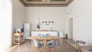 A modern kitchen with a dining area, featuring a patterned floor, a white refrigerator, a microwave, a sink, and a shelf with potted plants. - Casa Darsena With Sea View Balcony by Wonderful Italy (Syracuse)