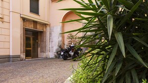 Ein Kopfsteinpflasterhof mit einem Motorrad in der Nähe eines Hauseingangs.