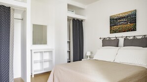 A bedroom with a bed, a bedside table, a nightstand, a window, and a painting on the wall. - Casa Ibla Duplex con Terrazza by Wonderful Italy (Ragusa)