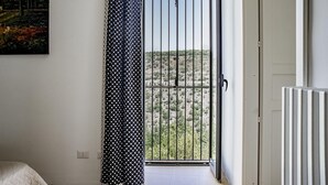 A room with a view of a hilly landscape through a barred window. - Casa Ibla Duplex con Terrazza by Wonderful Italy (Ragusa)