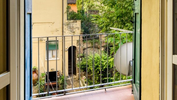 A balcony with a metal railing, a view of neighboring buildings, and a clear sky. - Castiglione Family Apartment by Wonderful Italy (Bologna)