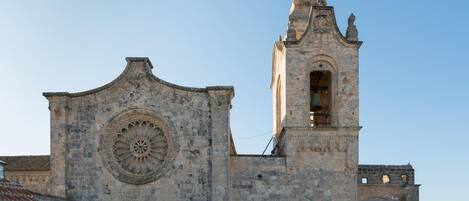 A historic church with a prominent circular window and a bell tower.