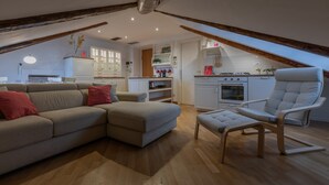 Un salon moderne avec un canapé d’angle, un banc rembourré et un fauteuil contemporain.