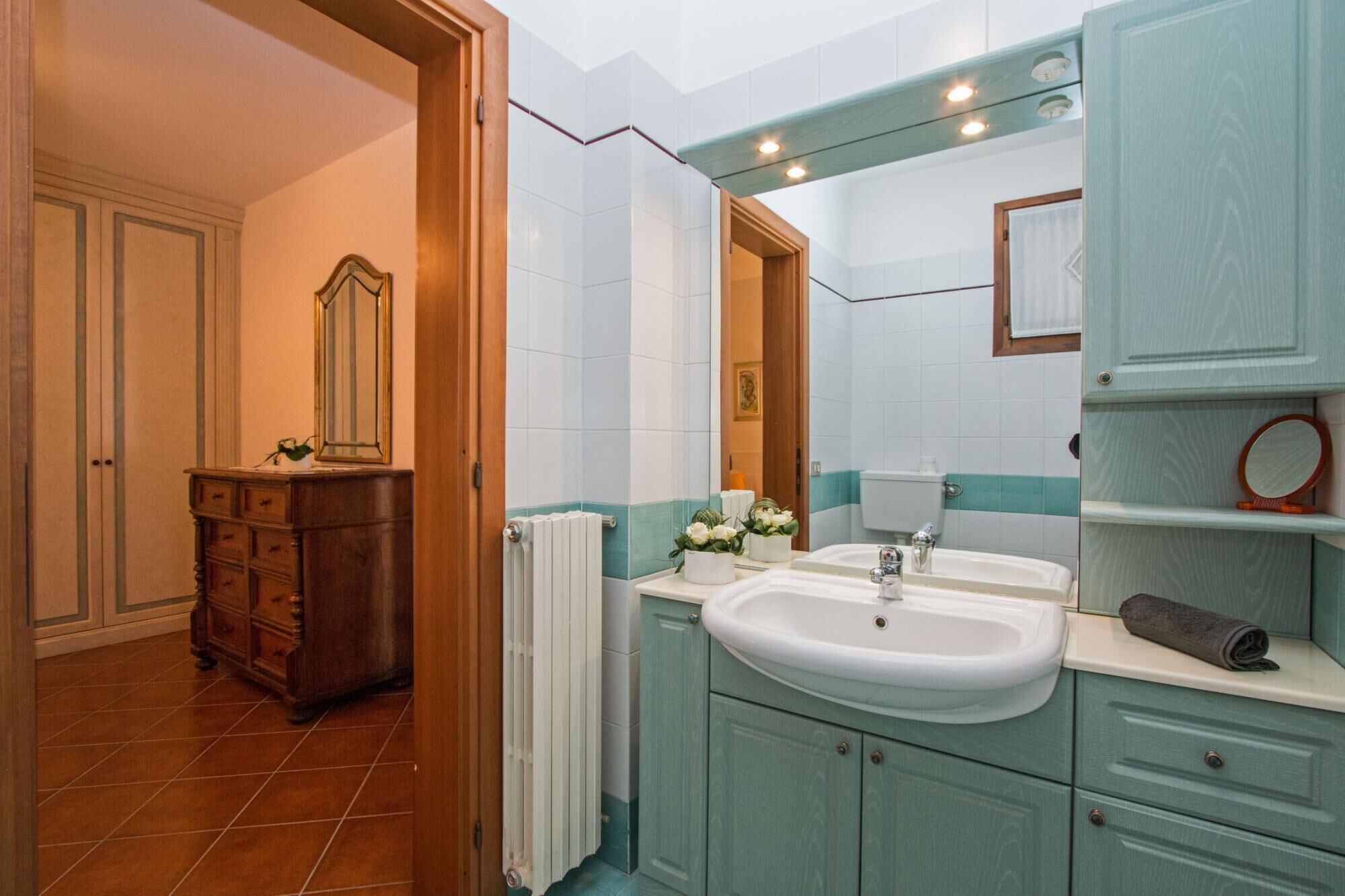 A bathroom with a double sink, a mirror, and a towel rack.