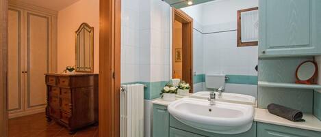 A bathroom with a double sink, a mirror, and a towel rack.