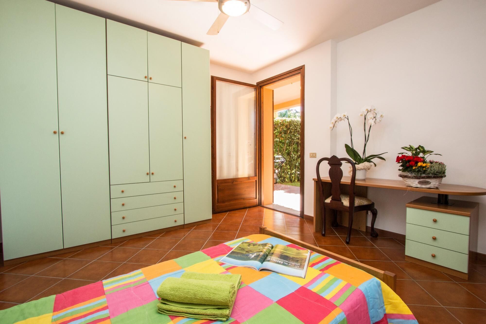 A bedroom with a bed, a desk, a chair, and a wardrobe.