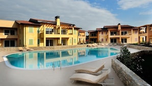 A pool area with lounge chairs and a clear sky. - Le Corti Caterina B2 Apartment by Wonderful Italy (Lonato del Garda)